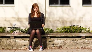 Person with laptop outside a university building